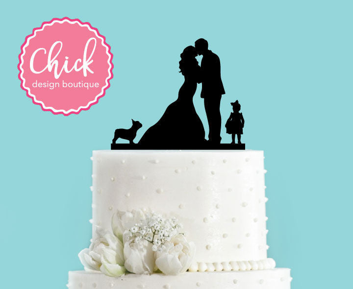 Couple Kissing with French Bulldog and Little Girl Standing with Bride and Groom Wedding Cake Topper